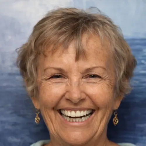 Smiling older woman with short hair against a blue background.