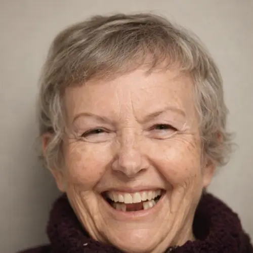 Elderly woman with short gray hair smiling broadly.